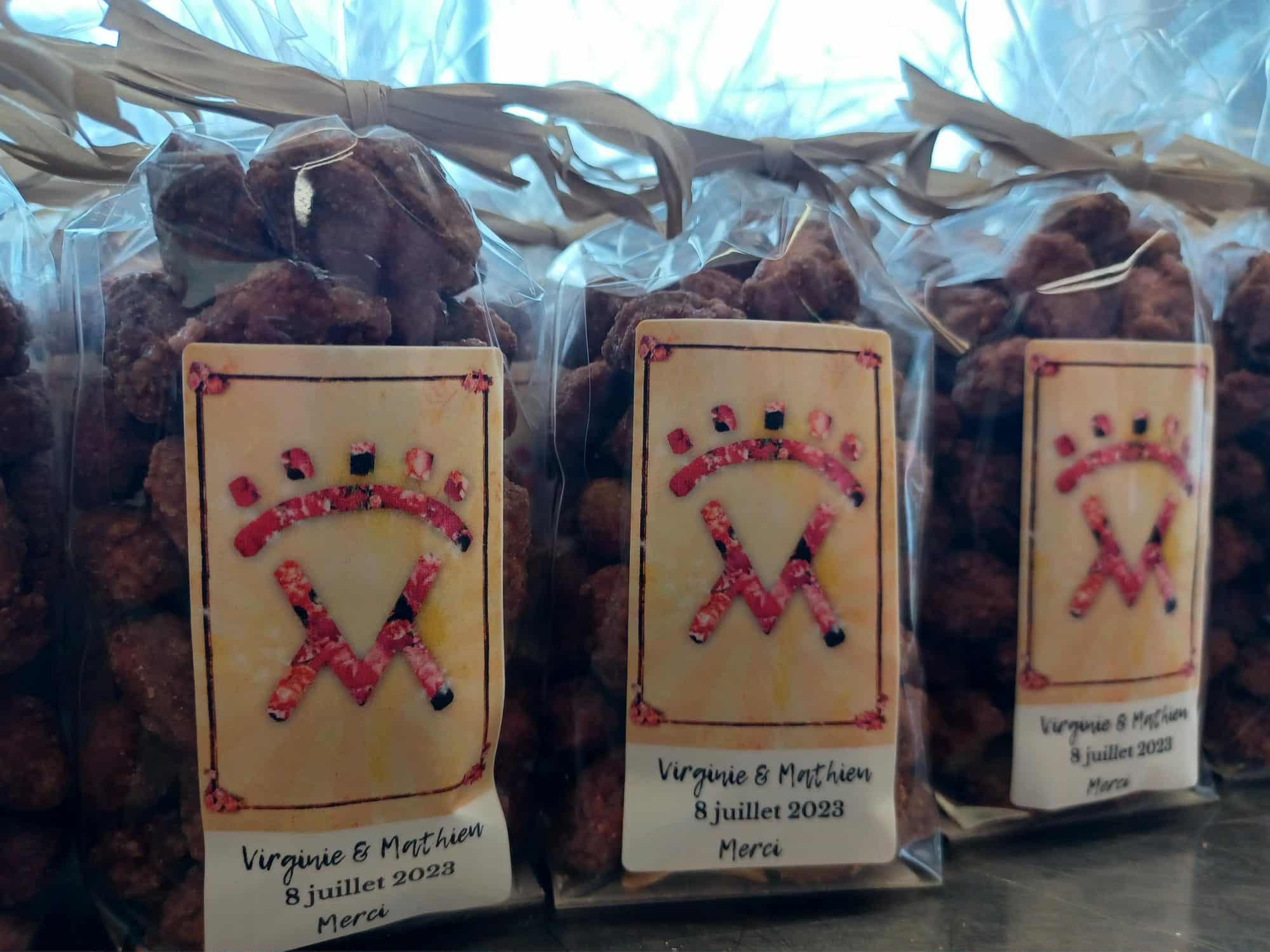 Sachets de pralines artisanales personnalisées pour mariage, avec rubans et étiquettes au nom des mariés.